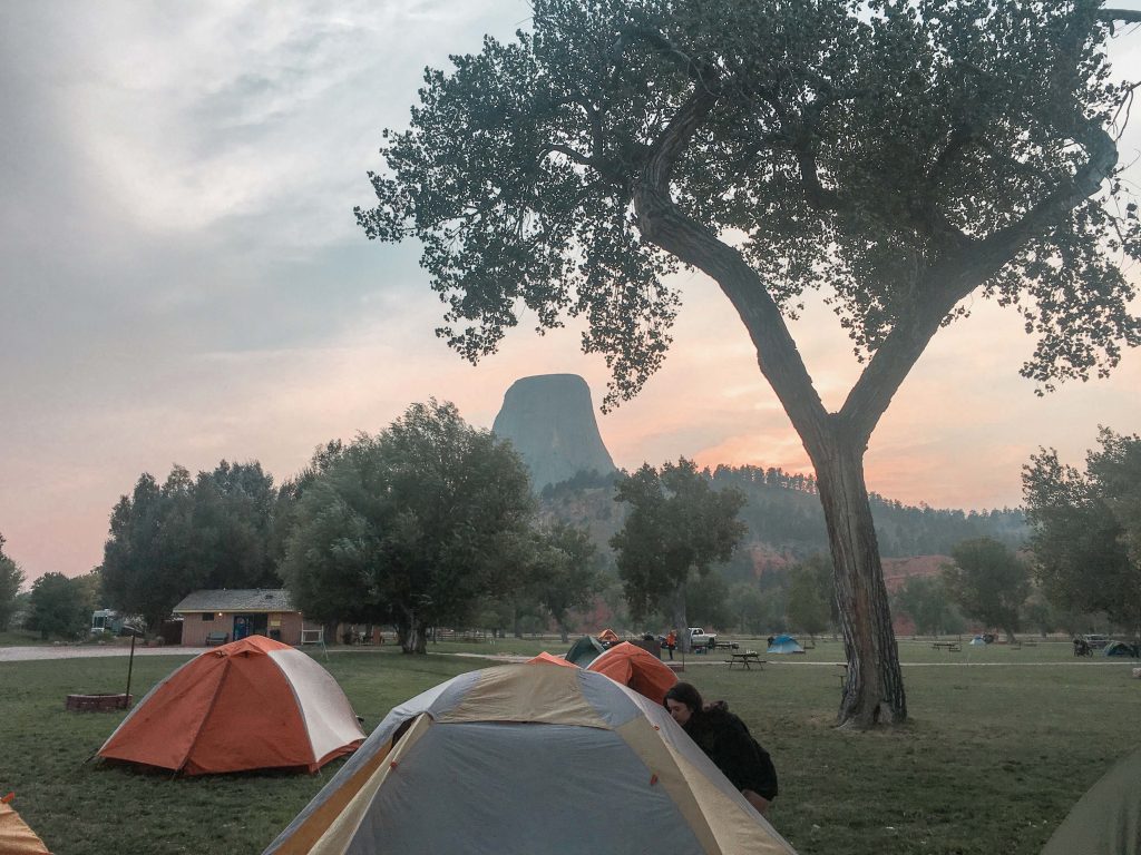 Road Trip Packing List Camping Guide Devils Tower in the background with pitched tents
