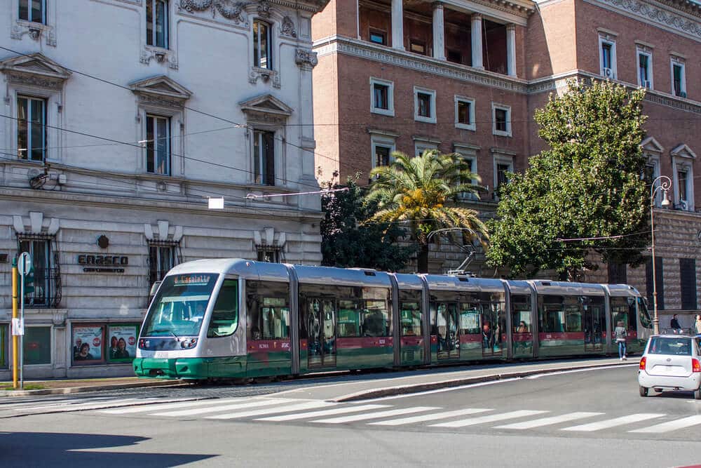 A green and white train in Rome.