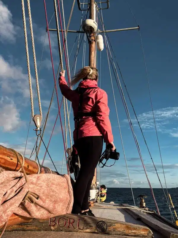 An Irish travel blogger standing on the deck of a sailboat.